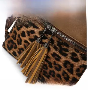 Détail du sac bandoulière imprimé léopard avec doubles fermetures éclair à pompons