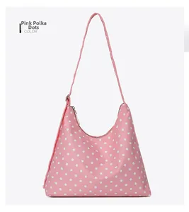 Detailed view of the pink polka dot nylon crescent shoulder bag with zipper closure