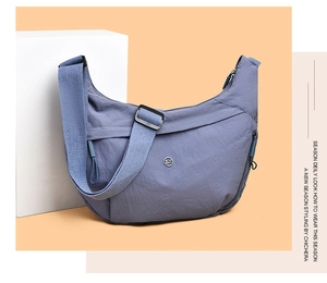 Close-up of semi-moon dumpling bag in mauve Oxford cloth with adjustable strap and logo