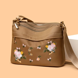 Khaki nylon crossbody bag with floral embroidery and three zipper compartments