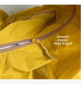 Detailed macro view of the smooth yellow zipper with matching woven pull cord on canvas tote