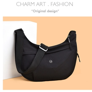 Detail of black crescent crossbody bag showing durable nylon texture and metal buckle