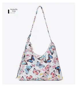 Detail view of pink butterfly print on white shoulder bag with matching long strap