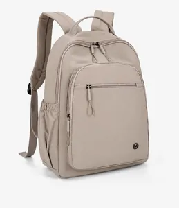 Side view of lightweight khaki nylon travel backpack with zippers and metal logo