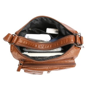 Sac bandoulière marron en cuir avec plusieurs zips montrant une grande capacité de rangement