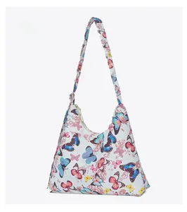 Detail view of large white shoulder bag featuring colorful butterfly patterns and zipper closure