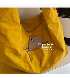 Detail of yellow pleated shoulder bag showing practical zipper pocket and large capacity