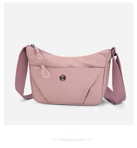 Vue latérale détaillée du sac bandoulière en nylon rose avec zip et logo métallique