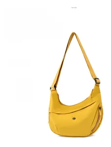 Detail of light yellow crescent bag showing durable nylon texture and adjustable wide strap