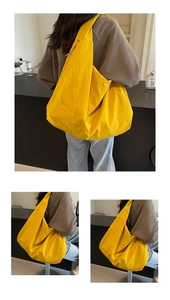 Detail view of bright yellow crescent crossbody bag made of textured nylon fabric