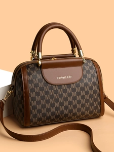 Detail of Boston bag showing brown M-letter pattern and golden hardware accessories