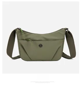 Détail de la sacoche en nylon vert olive avec fermeture éclair et logo circulaire