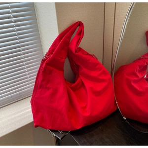 Detail of red oversized canvas tote bag with textured fabric and drawstring accents