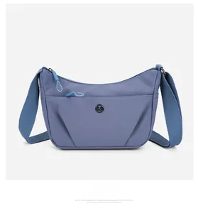 Vue détaillée d'un sac bandoulière en nylon bleu Morandi avec logo et large sangle