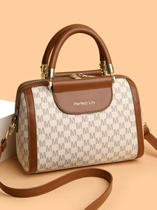 Detail of Boston bag with monogram print, leather trim, and adjustable shoulder strap