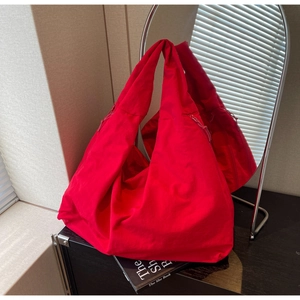 Macro detail of red canvas hobo tote featuring soft fabric texture and zipper closure
