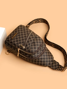 Detail of vintage brown chest bag showing three gold zippers and 'M' pattern texture