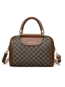 Close-up of Boston handbag with M-pattern monogram, leather handle and gold hardware