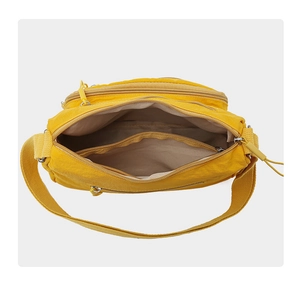 Detailed top view of a yellow waterproof crossbody bag showing multiple inner compartments