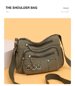 Detail view of military green nylon shoulder bag with multiple zip pockets and wide strap