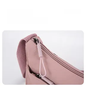 Vue détaillée du sac à bandoulière en nylon montrant la fermeture éclair et la sangle