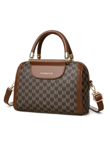 Macro view of brown Boston bag showing detailed M letter pattern and golden hardware