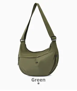 Detail view of olive green crescent crossbody bag with adjustable strap and side pocket