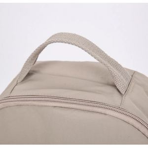Nahaufnahme von khakifarbenem Nylon-Rucksackgriff und Reißverschluss-Nähdetail