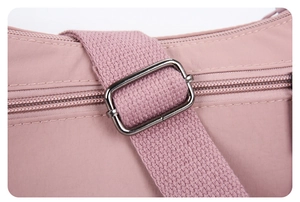 Détail de la bandoulière tissée réglable et boucle en métal sur le sac en nylon