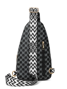 Close-up of black and white crossbody bag featuring M-pattern and gold hardware details