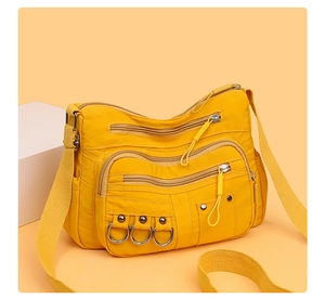 Detailed view of yellow nylon crossbody bag with multi-zipper pockets and wide strap