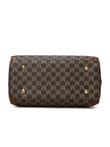 Detail view of the handbag base showing M-pattern monogram and gold protective metal feet
