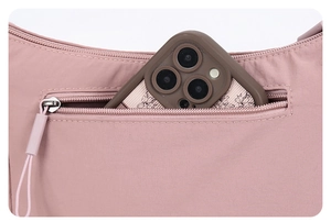 Gros plan du sac en nylon rose montrant une poche zippée arrière pour ranger un téléphone