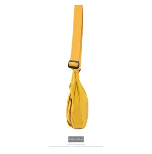 Side view of yellow oxford fabric crossbody bag with wide canvas strap and zipper pocket