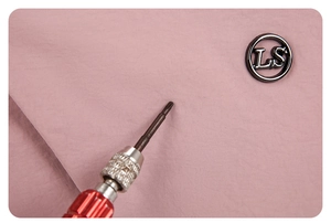 Détail du tissu en nylon rose montrant le test de résistance et l'emblème en métal