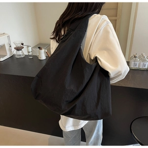Close-up of minimalist black canvas tote bag with relaxed silhouette for daily use