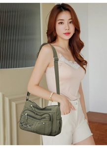 Detailed view of army green nylon crossbody bag with functional zipper pockets and rings