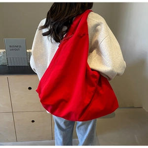 Rear view of model wearing a large red canvas tote bag for casual daily commuting