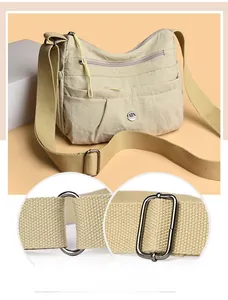 Detail view of adjustable strap and multi-pocket nylon crossbody bag with metal logo