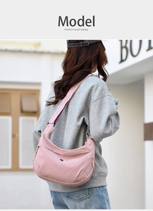 Detailed back view of a pink nylon crescent bag worn on a model for daily commute