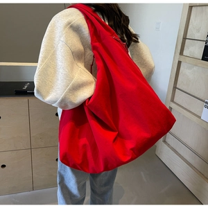 Detail view of large red canvas crescent bag showing high-density fabric and zipper closure