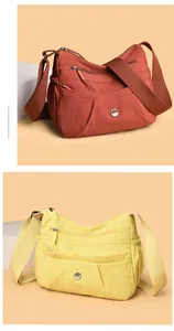 Detail of red-brown and yellow nylon crossbody bags with multi-zipper pockets