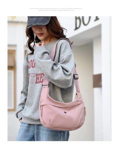 Detail of light pink oxford crescent bag with adjustable wide fabric shoulder strap