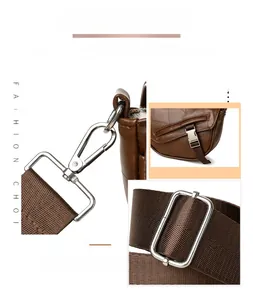 Detailed silver metal hardware buckle and dark brown fabric strap on women handbag