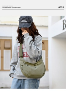 Close-up of olive green crescent canvas bag featuring wide strap and circular logo detail