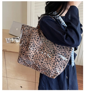 Close-up of leopard print tote bag being carried in a modern office environment