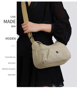 Close-up of beige nylon crossbody bag with multi-layer pockets and adjustable strap