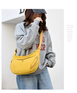 Model wearing bright yellow oxford half-moon crossbody bag with wide adjustable shoulder strap