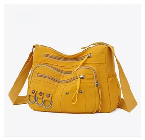 Micro side view of yellow multi-pocket crossbody bag in durable waterproof nylon