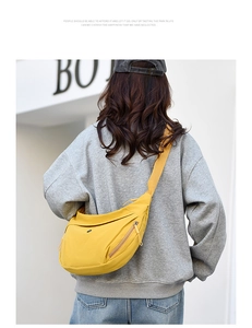 Detail of yellow nylon crossbody bag with adjustable strap worn by a model in street style